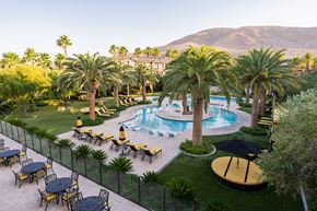 Las Vegas apartment for rent - A pool surrounded by palm trees and lounge chairs.