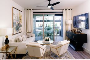 Las Vegas apartment for rent - A living room with a white sofa, a coffee table, and a ceiling fan.
