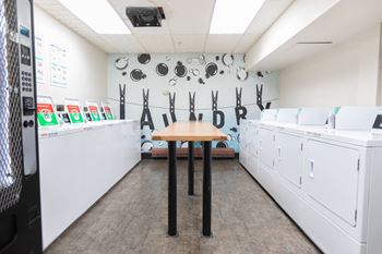 A washer and dryer room with a table in the middle