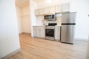 A kitchen with stainless steel appliances and white cabinets