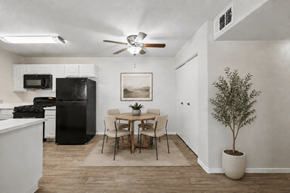 Las Vegas apartment for rent - A kitchen with a black refrigerator and a dining table with chairs.