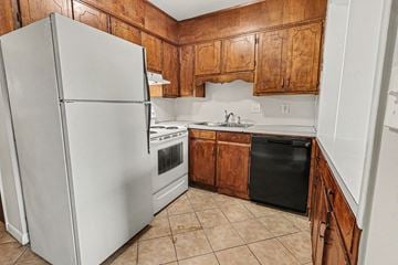 Hoover apartment for rent - A kitchen with a white refrigerator and wooden cabinets.