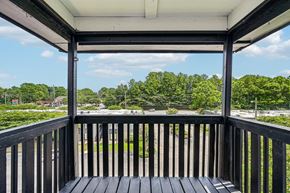 Hoover apartment for rent - A wooden deck with a view of a parking lot and trees.
