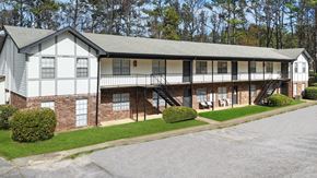 Birmingham apartment for rent - A white and black building with a grey roof and a green lawn in front.