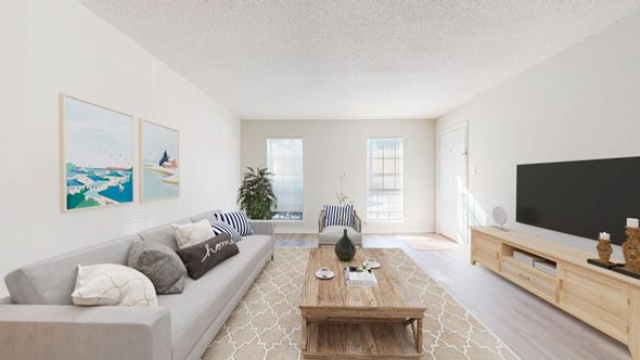 Birmingham apartment for rent - A living room with a grey couch, a wooden coffee table, and a large painting on the wall.