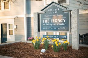 Arlington apartment for rent - A sign for The Legacy at Arlington Center Luxury Apartments is displayed in front of a building.
