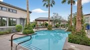Peoria triplex for rent - A swimming pool surrounded by palm trees and a building at Grandstone at Sunrise, Peoria, AZ