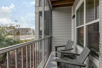 Two chairs are on a porch