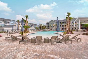 A pool surrounded by chairs 