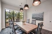 Bradenton apartment for rent - A conference room with a long table and chairs, a plant, and a painting on the wall at The Stadler Luxury Apartments, Bradenton, 34210