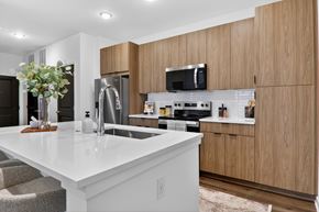 Nampa apartment for rent - A modern kitchen with wooden cabinets and a white countertop.at The Logan Luxury Apartments, Nampa, ID, 83651