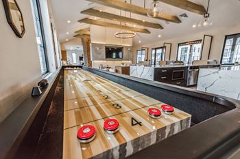 A shuffleboard table in the middle of a game room