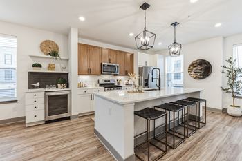An open kitchen with a large island with bar stools