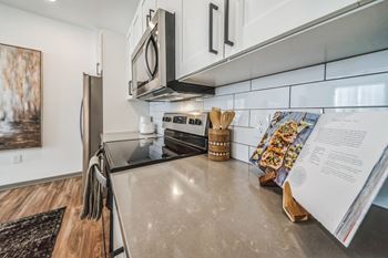 An updated kitchen with stainless steel appliances and white cabinets