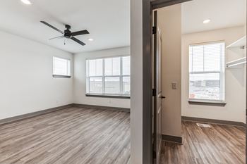 An empty living room with a ceiling fan and a window