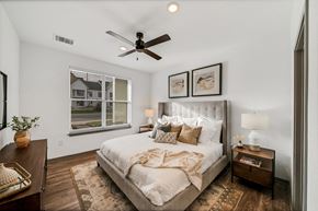 Wyoming townhouse for rent - a bedroom with a large bed and a ceiling fan at The BLVD at Wilson Crossings, Wyoming