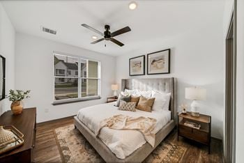 A bedroom with a large bed and a ceiling fan