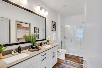 A bathroom with a large mirror and a toilet and a shower