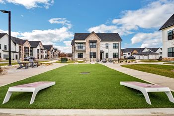 A green lawn with benches in front of houses