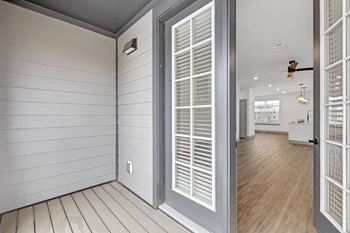 The view of a hallway from a home with white walls and doors