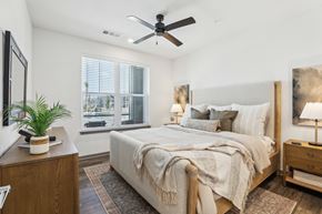 Rockledge apartment for rent - A bedroom with a large bed, a ceiling fan, and a window with blinds. at The Junction at Rockledge Apartments, Florida
