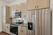 North Venice triplex for rent - A modern kitchen with a stainless steel refrigerator and a microwave above the stove. at The Sophia, Venice, FL, 34275