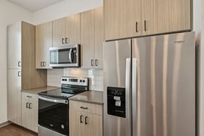 North Venice triplex for rent - A modern kitchen with a stainless steel refrigerator and a microwave above the stove. at The Sophia, Venice, FL, 34275