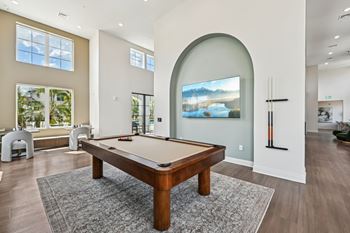 A pool table in a room with a painting on the wall.