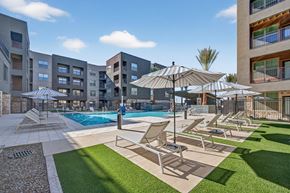 Phoenix apartment for rent - A sunny day at the pool with chairs and umbrellas.