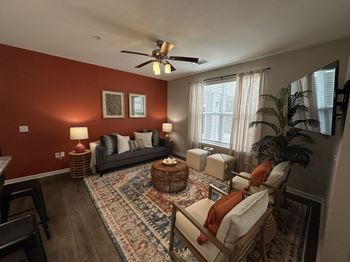A living room with red walls and a ceiling fan