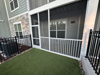 A balcony with a black railing and a green lawn.