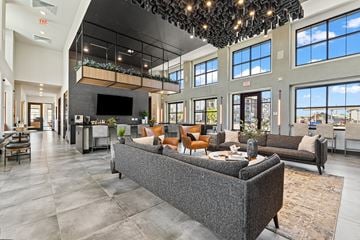 Nampa apartment for rent - A modern living room with a grey sofa and a chandelier.