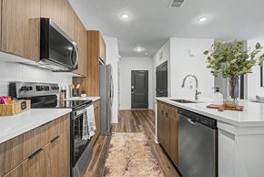 Nampa apartment for rent - A modern kitchen with dark wood cabinets and stainless steel appliances.