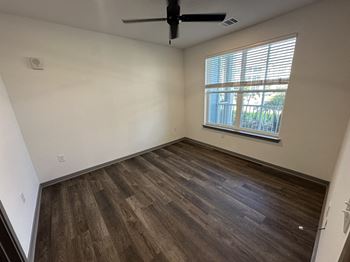 An empty room with wooden floors and a window