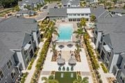 Ellenton apartment for rent - an aerial view of a swimming pool in a row of houses at Palm Grove in Ellenton, FL 34222