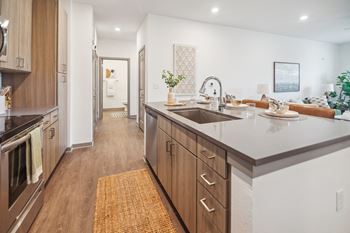 A large kitchen with a sink and counter top in a new home