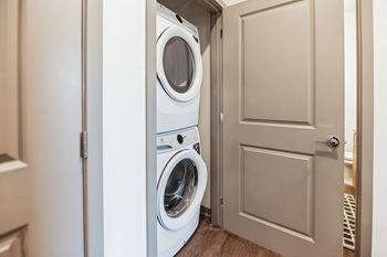 A washer and dryer in a small laundry room with a door