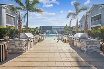 A resort style pool with two hot tubs and palm trees