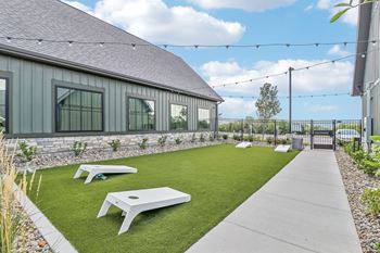 The backyard of a house with a lawn and picnic tables
