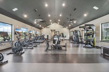 A gym with cardio machines and weights on the floor