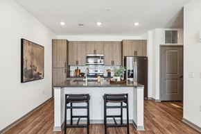 San Tan Valley apartment for rent - a kitchen with a large island with two stools and a stainless steel refrigeratorat Stella, San Tan Valley, 85143