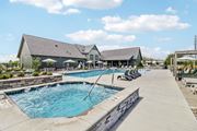 Raymore apartment for rent - a swimming pool with chairs and a building in the background at The Depot in The Depot Raymore, MO 64083