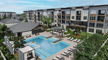 Wheat Ridge apartment for rent - A large swimming pool surrounded by lounge chairs and umbrellas is the centerpiece of a resort-style outdoor area.