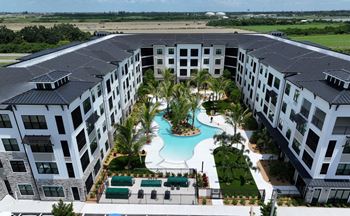 A large building complex with a pool in the middle