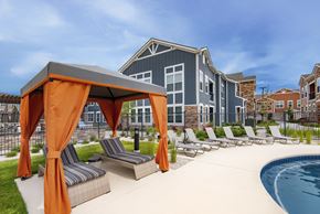 Parker apartment for rent - an outdoor pool with lounge chairs and a building in the background at Watermark on Twenty Mile, Colorado 80134