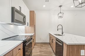Buckeye apartment for rent - a renovated kitchen with marble counter tops and wooden cabinets at The Maddox Luxury Apartment Homes, Arizona