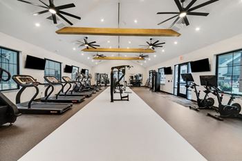 The gym with treadmills and other exercise equipment at the flats at west end