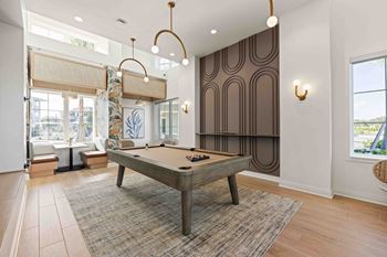 A pool table is in the middle of a room with a brown carpet