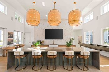 A kitchen with a bar area and a television mounted on the wall