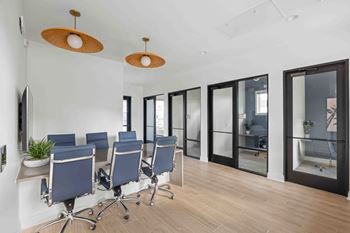 A conference room with blue chairs and wooden floors
